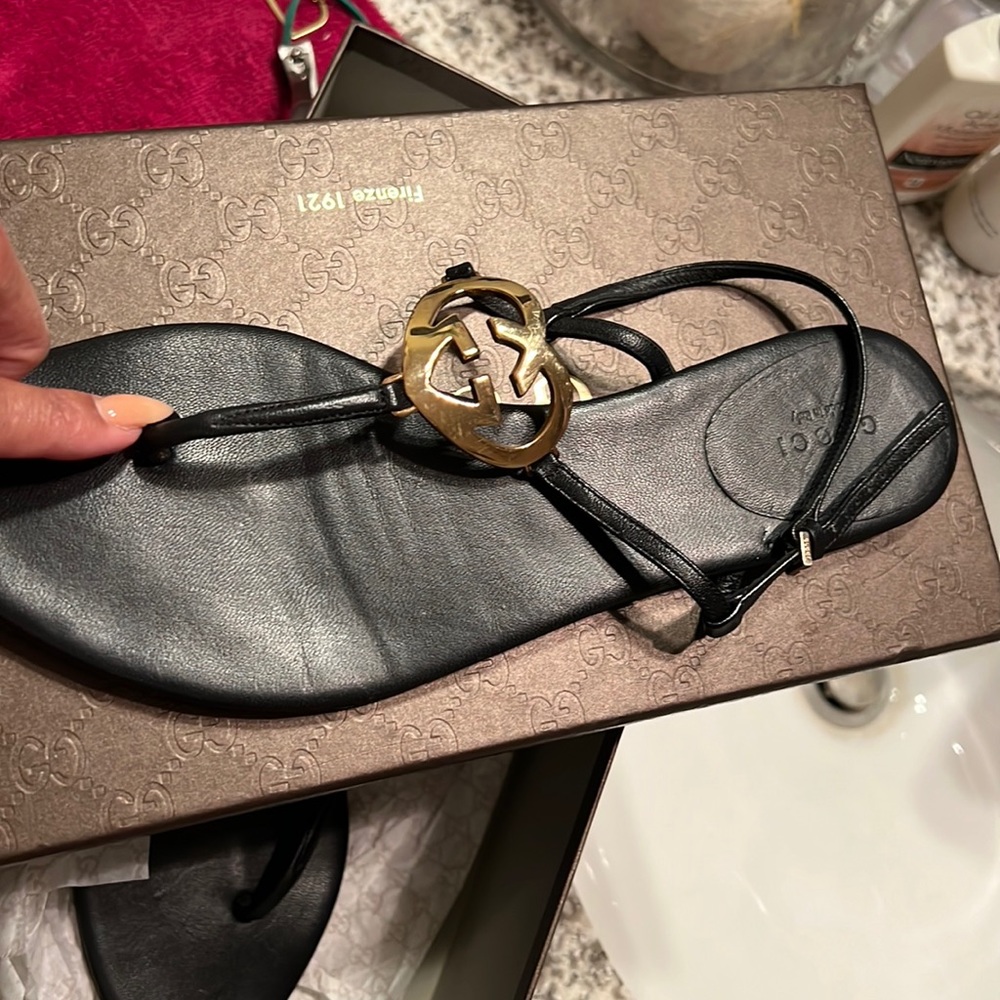 Blk gucci leather sandal gold g hardware on top of shoe